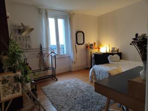 ein Schlafzimmer mit einem Bett und einem großen Fenster in der Unterkunft Villa Maria in Condé-Sainte-Libiaire