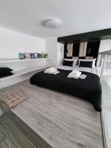 une chambre avec un grand lit avec une tête de lit noire dans l'établissement Apartments by Radecka Zarembowicza Wrocław Lotnisko, à Wrocław