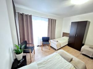 a bedroom with a bed and a couch and a chair at Kozienice Dream Hostel 