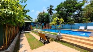a swimming pool with a bench next to a fence at Thinaya Lake Resort in Anuradhapura