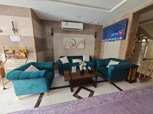 a living room with two blue couches and a table at شقق سويت النزهة للشقق المخدومة اقتصادي in Jeddah