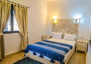 a bedroom with a bed and a window at Dar Lily, villa familiale avec piscine et services in Skoura