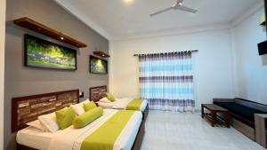 a bedroom with two beds and a flat screen tv at Thinaya Lake Resort in Anuradhapura
