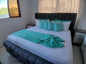 ein Schlafzimmer mit einem großen Bett mit blauen und weißen Kissen in der Unterkunft Hermosa villa familiar cucu's home beach in Río San Juan