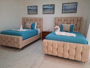 ein Schlafzimmer mit zwei Betten und einer Couch in der Unterkunft Hermosa villa familiar cucu's home beach in Río San Juan