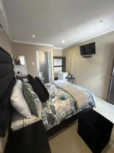 una camera da letto con un letto e una TV a schermo piatto di Themba's guesthouse a Pongola