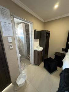 bagno con lavandino, doccia e servizi igienici di Themba's guesthouse a Pongola