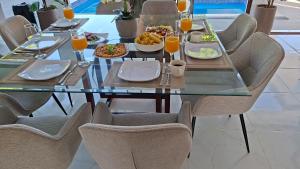 ein Esstisch mit Tellern voller Essen und Orangensaft in der Unterkunft Hermosa villa familiar cucu's home beach in Río San Juan + 29 Fotos