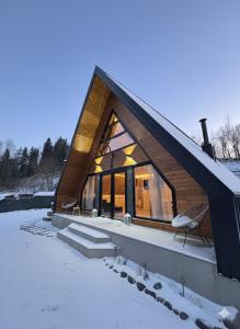 a cabin in the snow with a roof at Riverside A-frame in Borsa