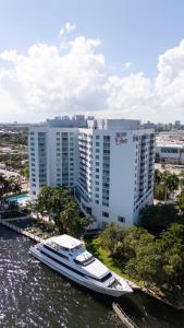 un bateau dans l'eau devant un bâtiment dans l'établissement Luxury Waterfront Condo Hilton Hotel Amenities Beach Pool Jacuzzi Jetskis Gym, à Fort Lauderdale
