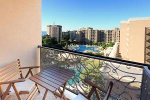 einen Balkon mit einer Holzbank und Stadtblick in der Unterkunft Royal Beach hotel Apartment Pool Sea B in Sonnenstrand