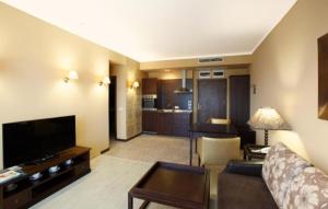 ein Wohnzimmer mit einer Couch und einem Tisch in einem Zimmer in der Unterkunft Royal Beach hotel Apartment Pool Sea B in Sonnenstrand