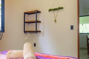 Una habitación con un estante en la pared y una cama. en Villa Bruno - Jungle Lodge Near Corcovado & Puerto Jiménez, en Puerto Jiménez