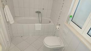 a white bathroom with a tub and a toilet at Apartment Vanja in Tučepi +25 photos