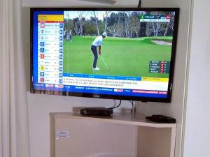 a television screen showing a golfer on a golf course at Sea Why in Natureʼs Valley