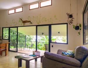 una sala de estar con un sofá y una mesa en Villa Bruno - Jungle Lodge Near Corcovado & Puerto Jiménez, en Puerto Jiménez