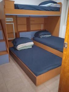 2 Etagenbetten in einem Zimmer mit blauer Bettwäsche in der Unterkunft Alquilo apto 8 personas en Caribbean Suit - Tucacas in Los Corales + 14 Fotos