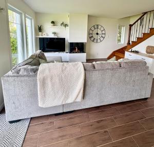 - un grand canapé dans le salon doté d'une cheminée dans l'établissement La maison de la Baie, à Chambord