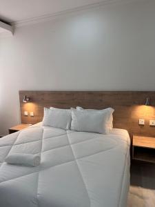 a large white bed with two pillows on it at Blue leaf apartments in Lusaka