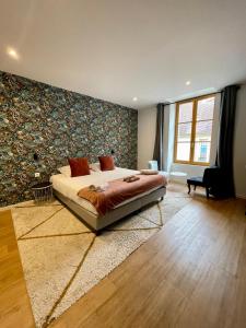 a bedroom with a large bed in a room with a wall at Hotel LA PLACE in Saint-Amand-Montrond
