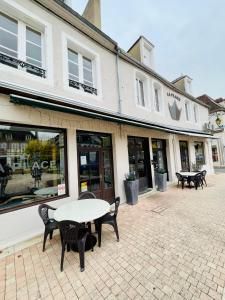 a table and chairs in front of a building at Hotel LA PLACE in Saint-Amand-Montrond