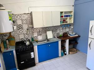 a small kitchen with blue and white cabinets at El cóndor in Balneario El Condor