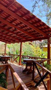 eine Holzterrasse mit einem Picknicktisch und einer Markise in der Unterkunft Encanto das Flores in Colinas Do Sul