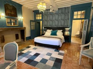 a large bedroom with a bed and a fireplace at Les Glycines Vézelay in Vézelay