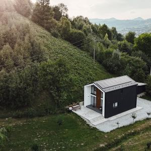 ein kleines schwarzweißes Haus auf einem Hügel in der Unterkunft Cozy HillSide in Borşa