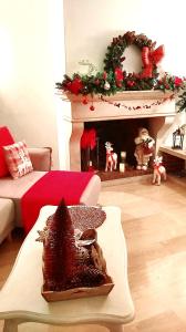 a living room with a christmas tree on a fireplace at L'Orée des Champs in Magny-Fouchard