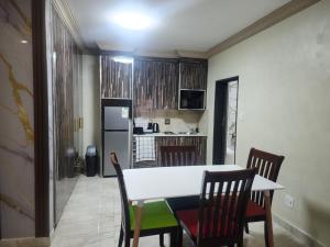 a kitchen with a table and chairs and a refrigerator at Lakefield Hotel in Benoni +14 photos