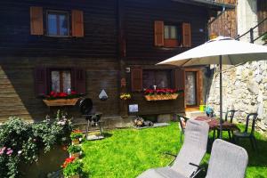 a backyard with a table and chairs and an umbrella at Appartement Valaisan typique in Guttet-Feschel