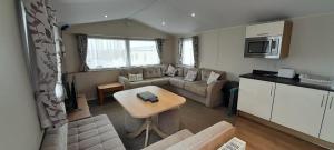 a living room with a couch and a table at Willerby Escapes in Lytchett Minster