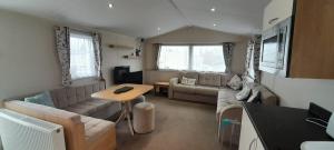 a living room with a couch and a table at Willerby Escapes in Lytchett Minster