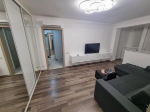 un soggiorno con divano e TV a schermo piatto di Ezzely apartment ParkLake a Bucarest