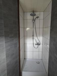 a shower in a tiled bathroom with a toilet at studio de l'ancienne gendarmerie in Mons +1 photo
