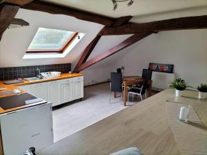 a kitchen and dining room with a vaulted ceiling at studio de l'ancienne gendarmerie in Mons