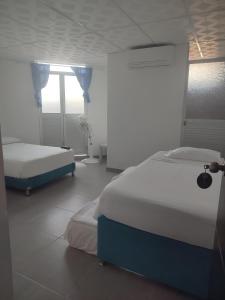 a bedroom with two beds and a window at tour & hosteleria moonlight in Villavieja