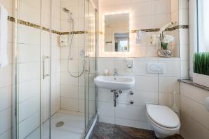 um banheiro com chuveiro, vaso sanitário e pia em Aristo Hotel em Filderstadt mais 37 fotografias