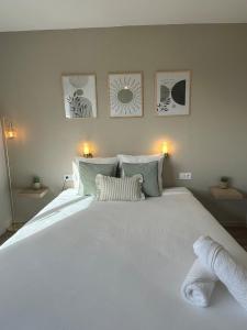 a bedroom with a large white bed with towels on it at Appart'Hôtel avec Netflix - Avignon gare TGV Confluence in Avignon