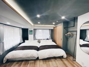 东京Plan A Tennozu Isle的有两张床和一面镜子的卧室