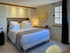 a bedroom with a large bed and a window at Les Glycines Vézelay in Vézelay