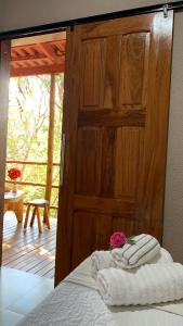 ein Schlafzimmer mit einer Holzwand und Handtüchern auf einem Bett in der Unterkunft Encanto das Flores in Colinas Do Sul