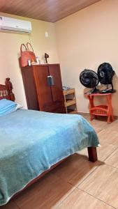 Un dormitorio con una cama con una manta azul y una cómoda. en Portal da Felicidade, en Maragogi