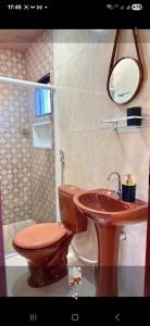 y baño con aseo de madera y lavamanos. en Portal da Felicidade, en Maragogi