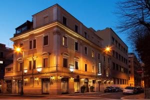 un edificio iluminado en una calle de la ciudad por la noche en Hotel Piemonte, en Roma