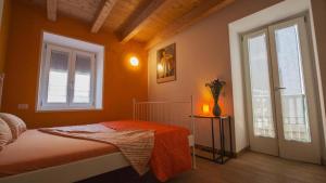 a bedroom with a bed with orange walls and a window at B&B Al Gatto Nero in Borgo