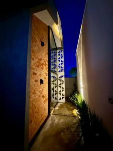 ein Flur, der nachts zu einer Tür in einem Gebäude führt in der Unterkunft Vila Chalés in Mucuri