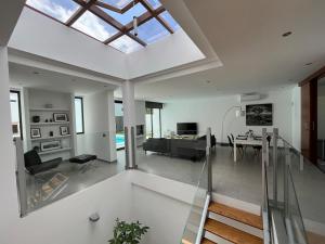 ein Wohnzimmer mit Oberlicht und einer Glastreppe in der Unterkunft Casa Blanca - Villa à Teguise avec piscine privée in Teguise