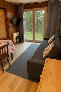 ein Wohnzimmer mit Sofa und Tisch in der Unterkunft Au Coeur du village de Prémanon in Prémanon